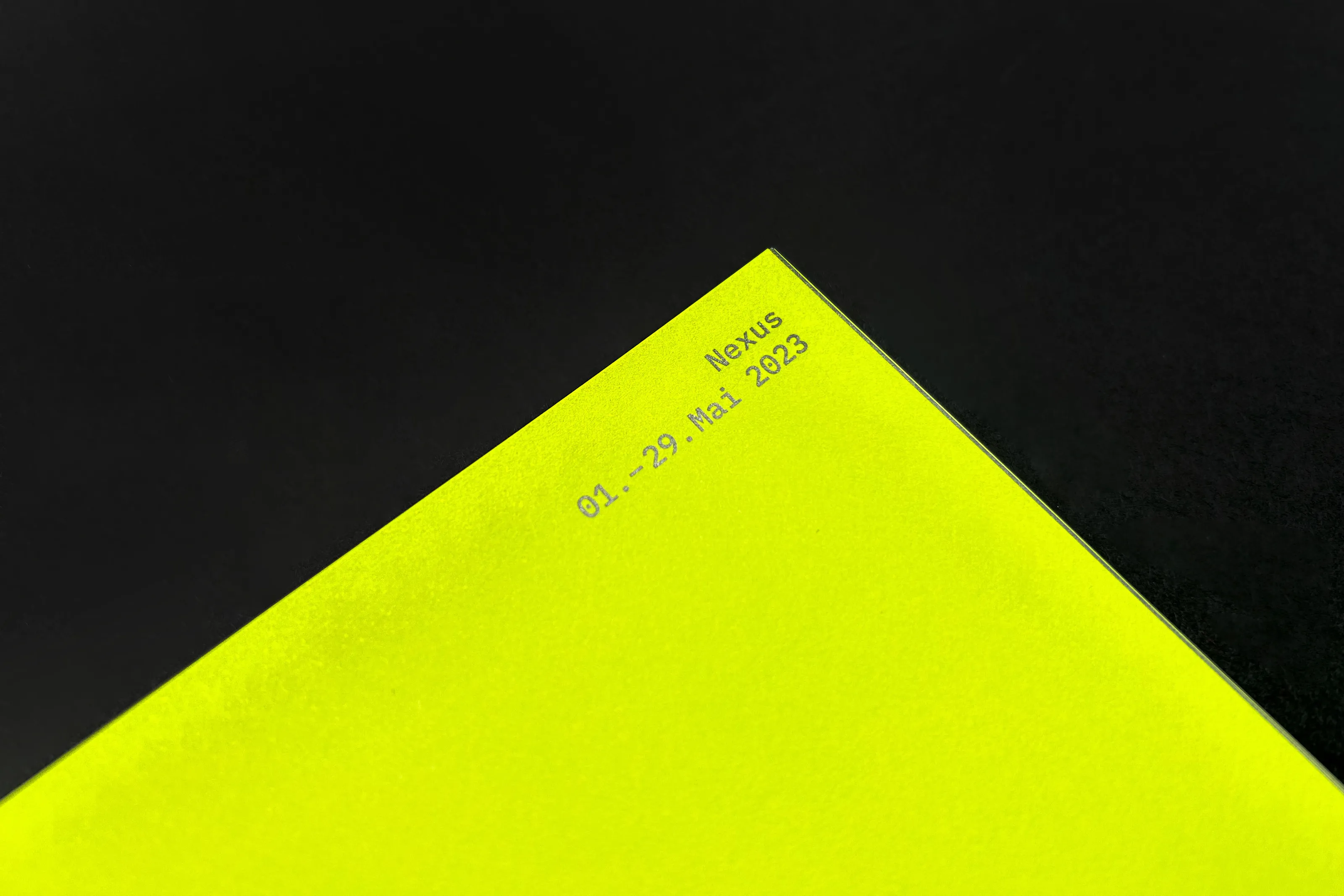Corner of a neon yellow page with "Nexus, 01–29 Mai 2023"