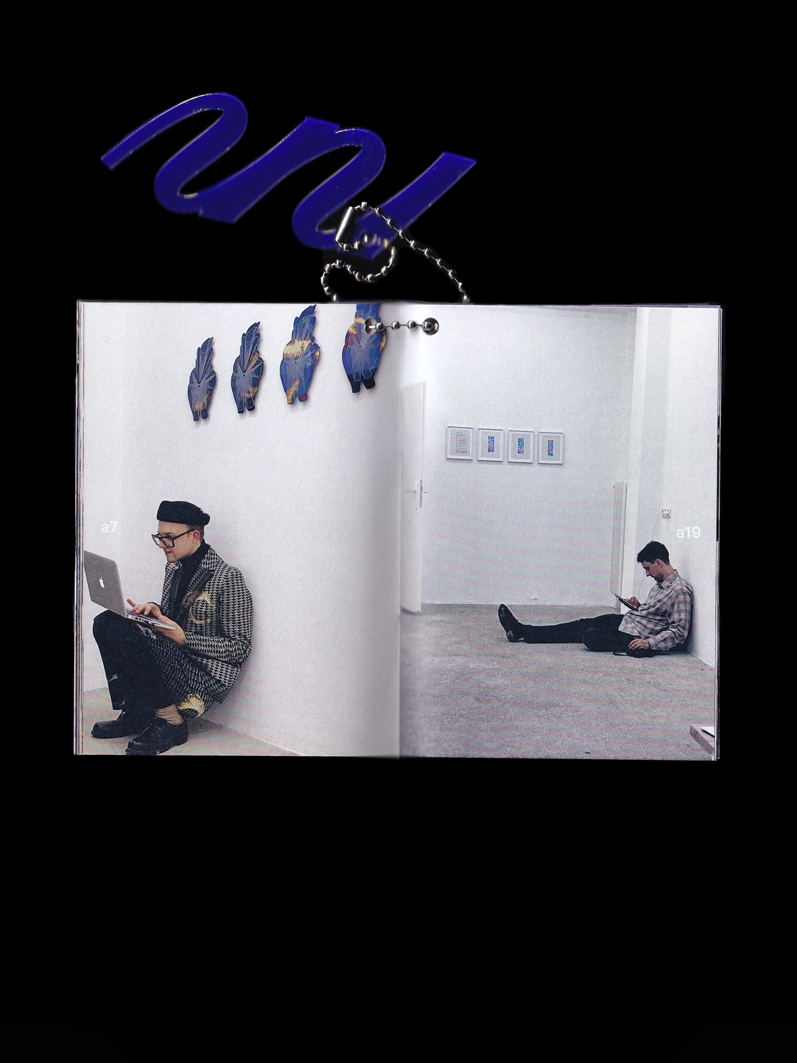 Open making-of booklet with a photo of people working in the gallery