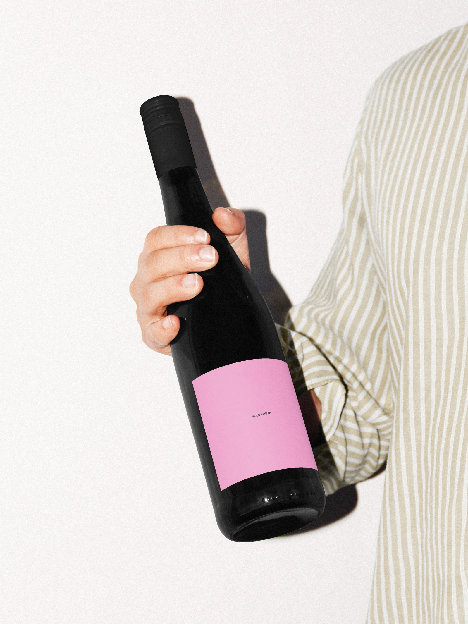 Hand holding a Wankwein bottle with a pink label