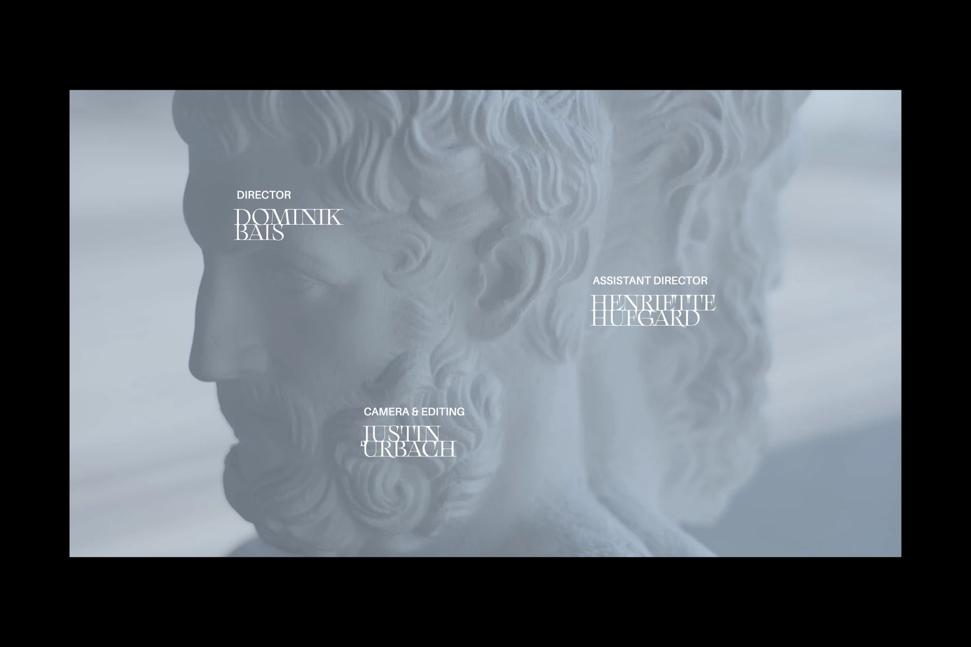 End credits with names beside a double-headed herm sculpture