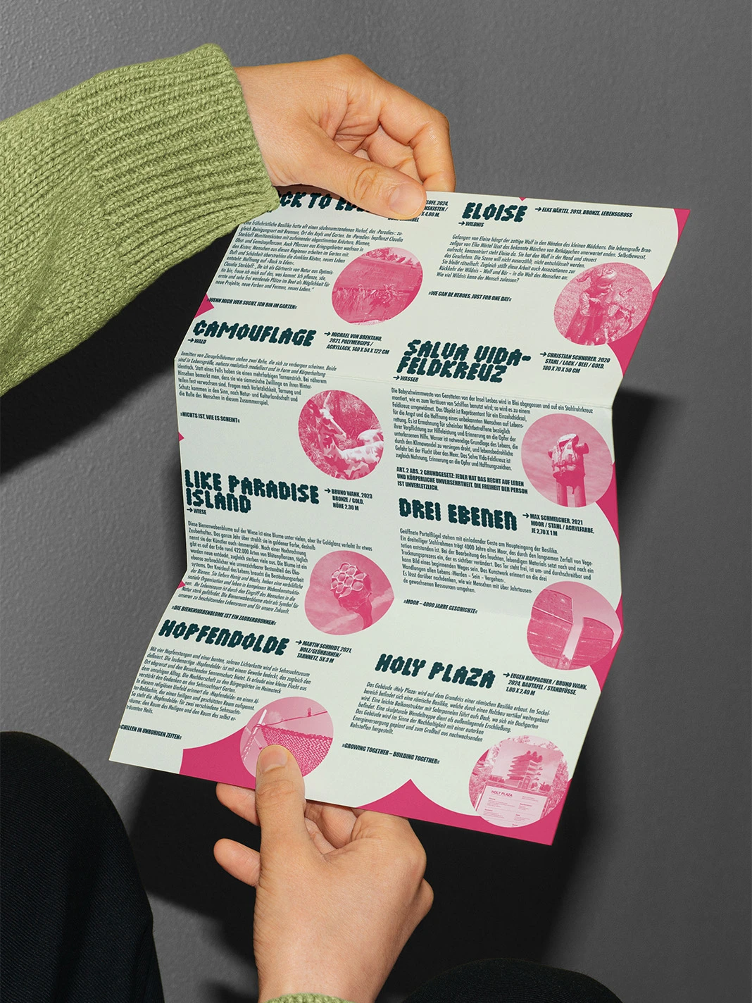 Hands holding an unfolded Holy Garden programme flyer
