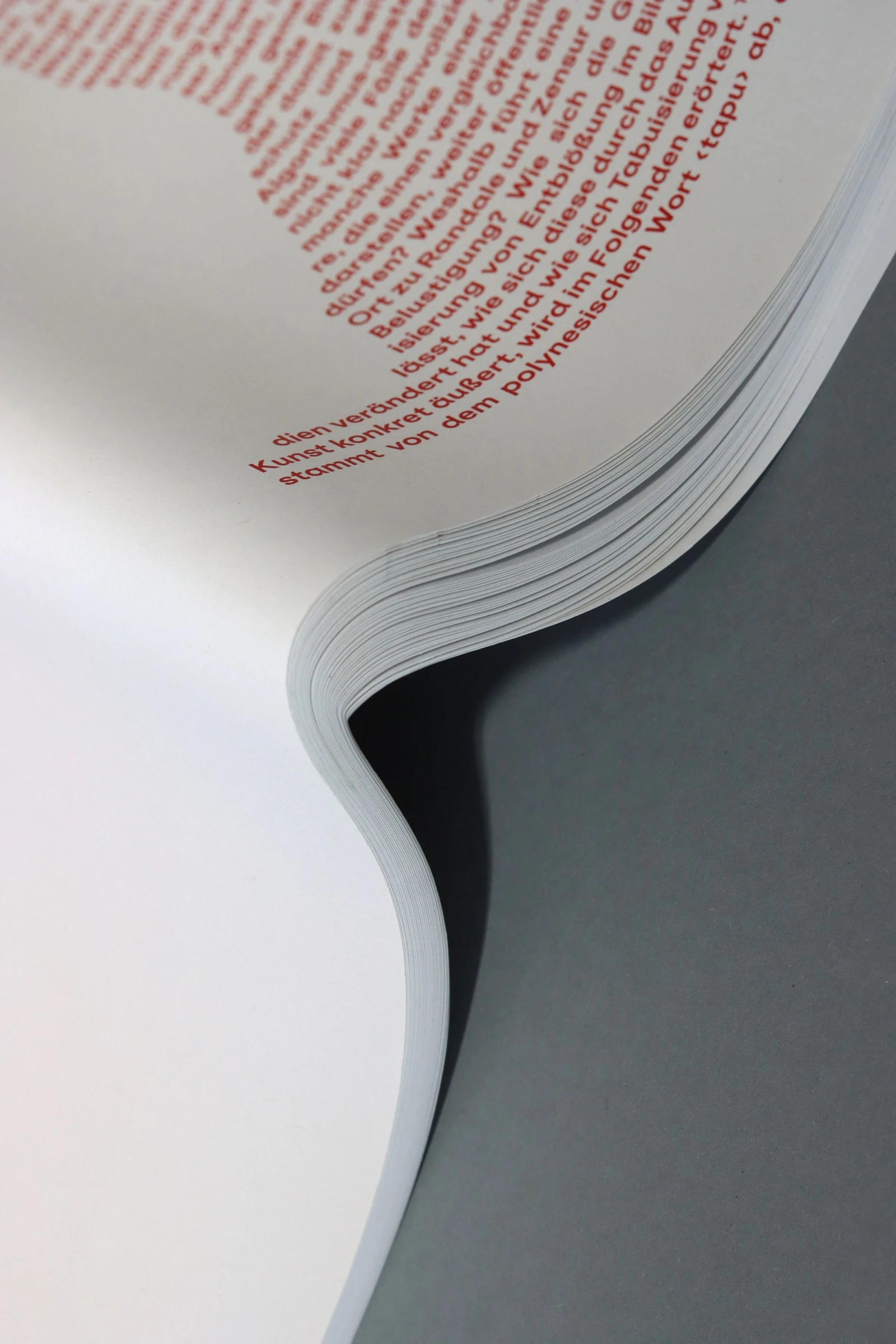 Open book with shaped red text across a white page