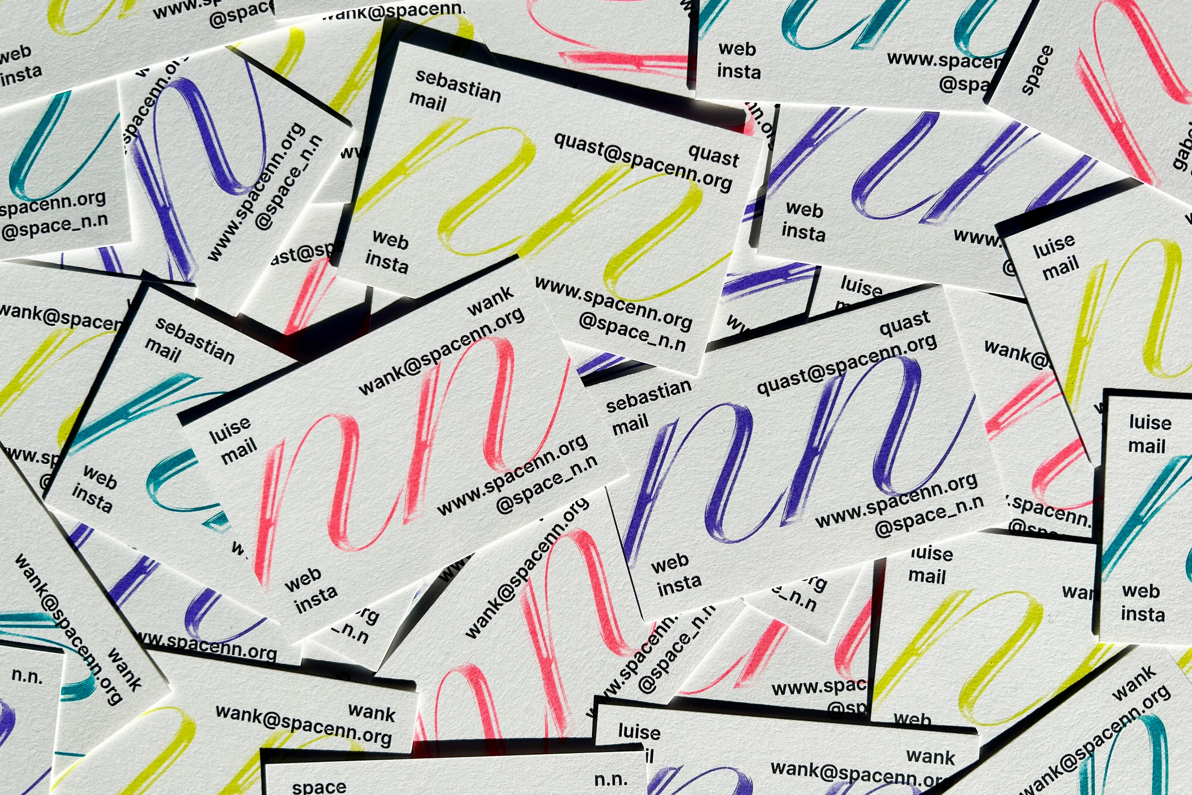 Pile of business cards with calligraphic n.n. overlays in different colours