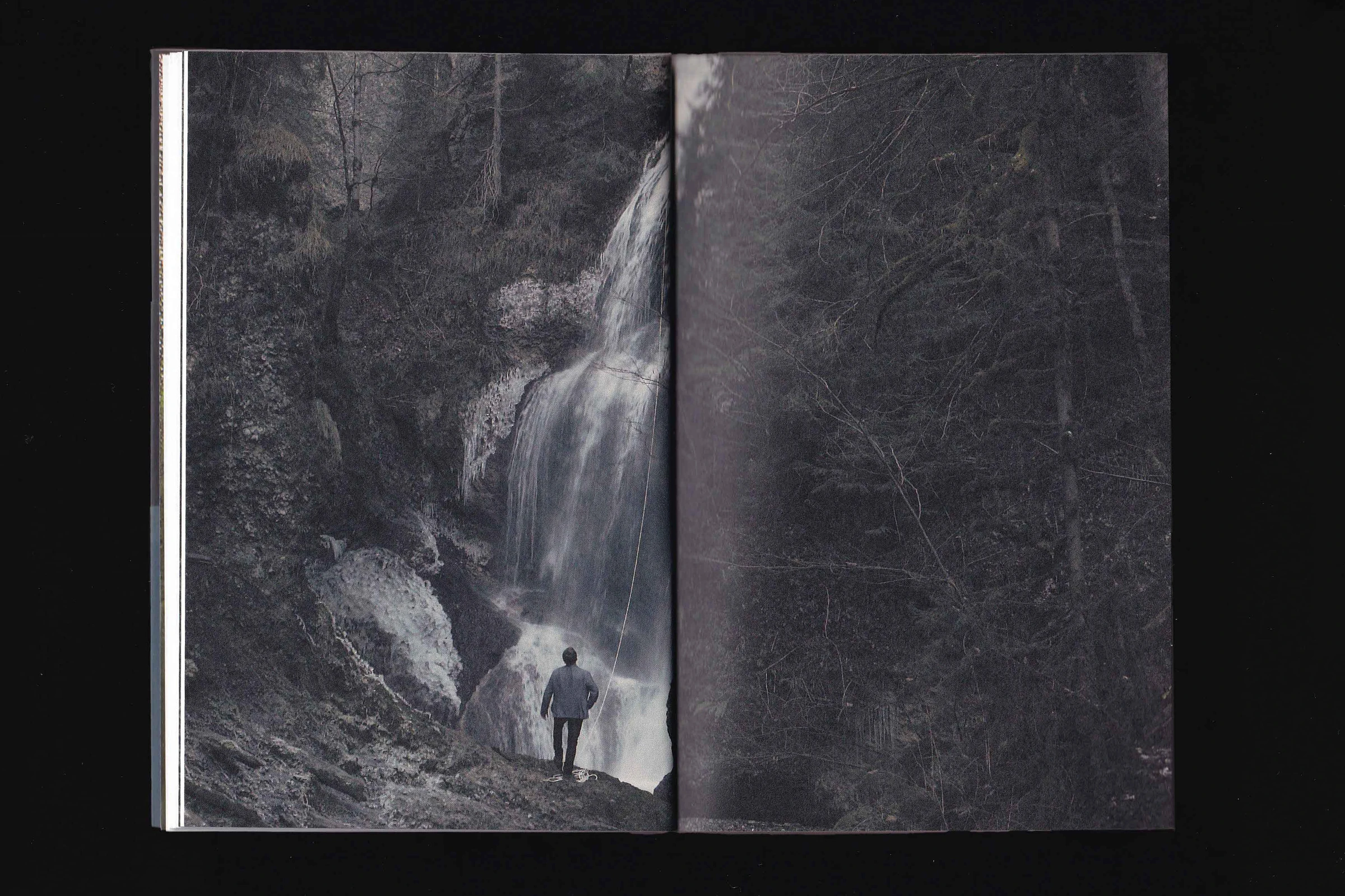 Spread with a black-and-white photo of a person at a waterfall in a forest