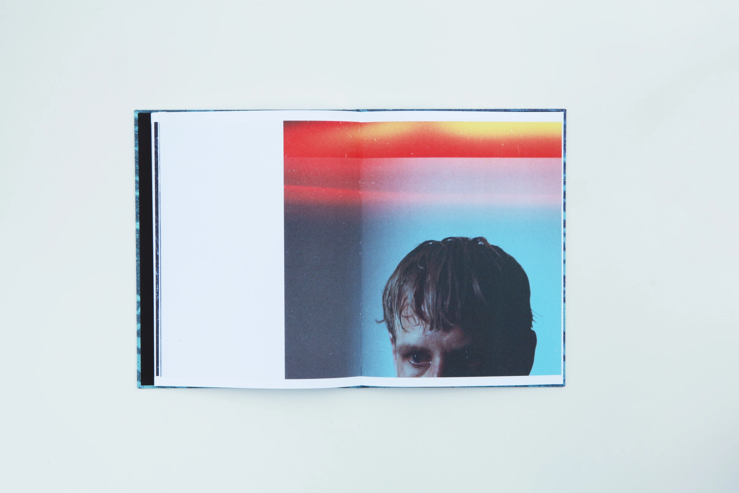 Open book with a face half-hidden below red and blue lights
