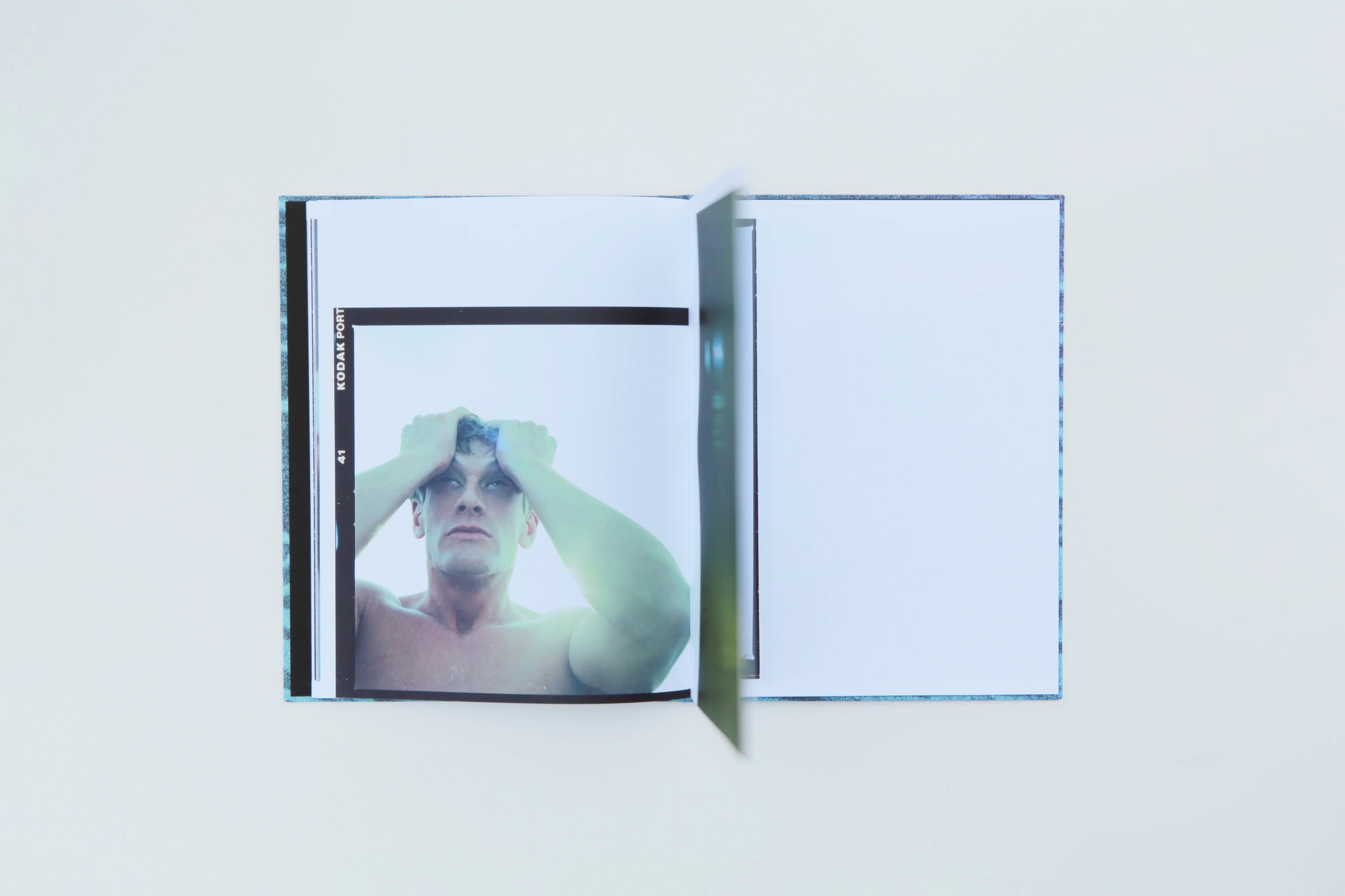 Open book with a man holding his hands over his head