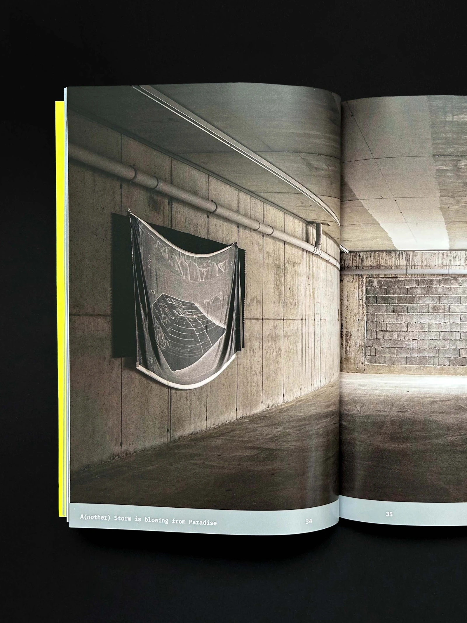 Catalog page with a textile work hanging in a concrete room