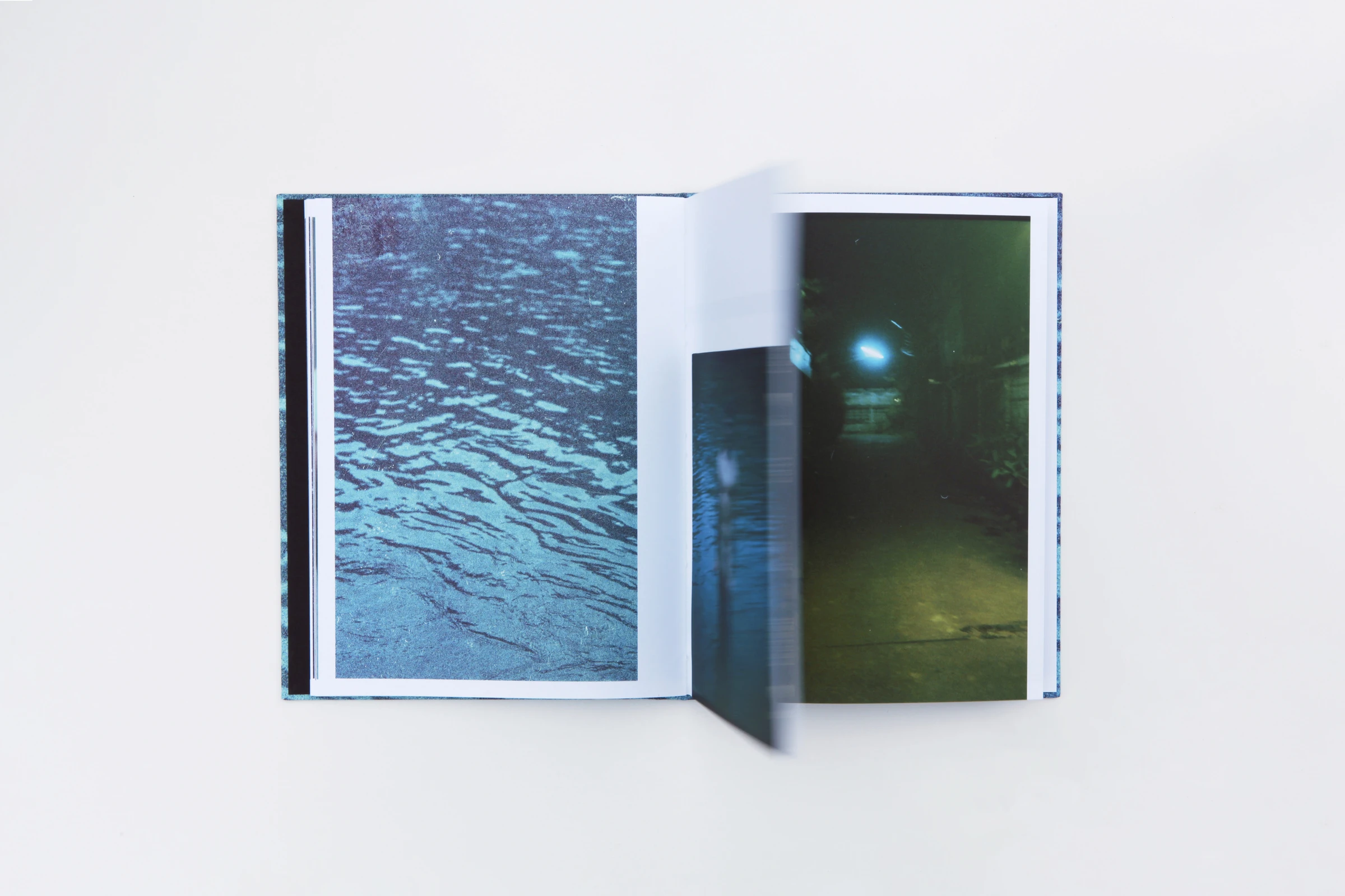 Open book with a photo of water and a night scene