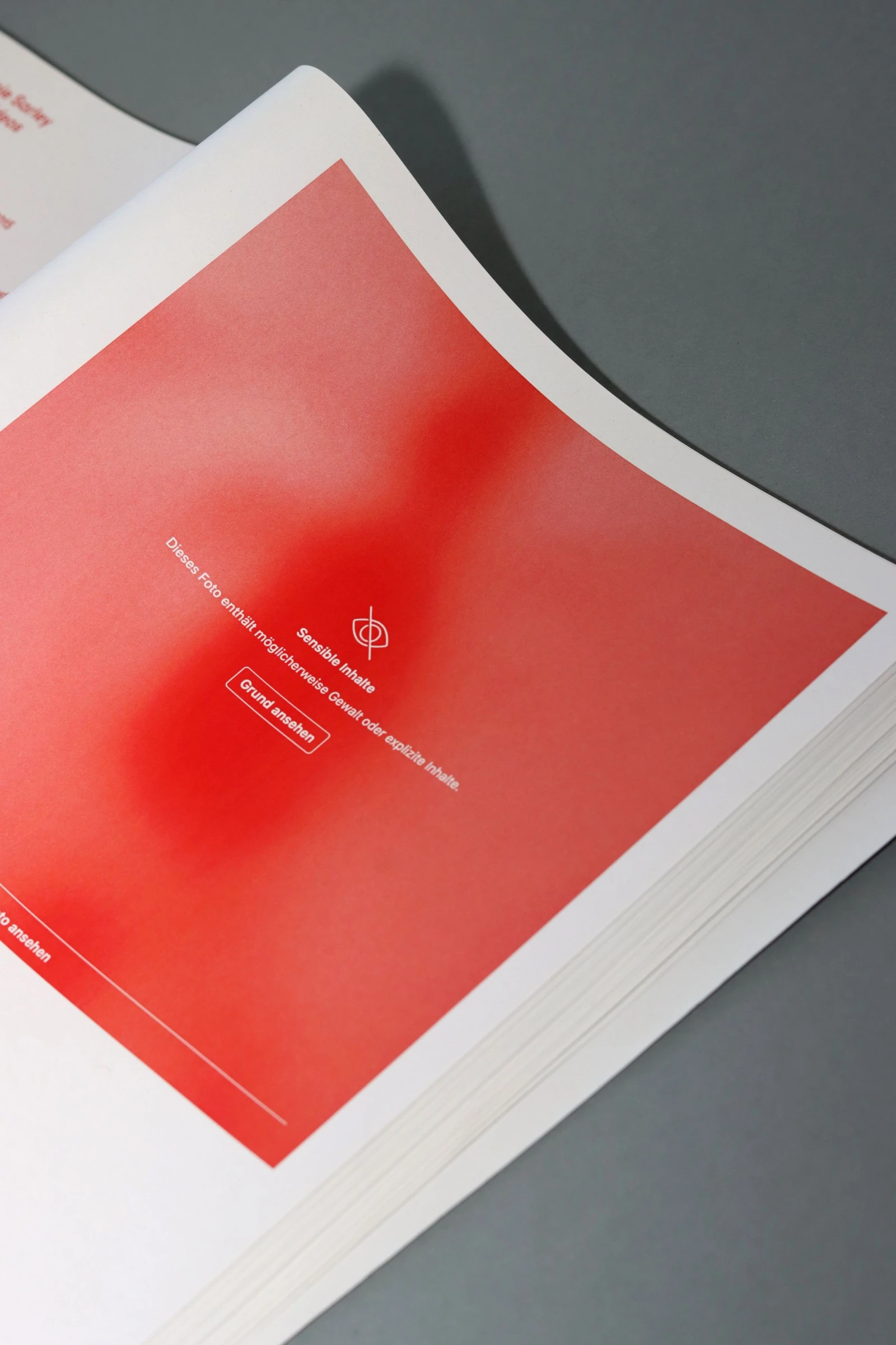Book open on a red page with a censored Instagram post